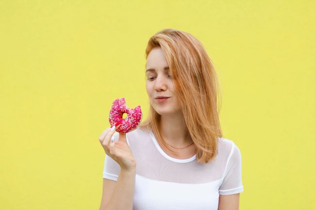 kobieta jedząca donuta odstępstwo od diety