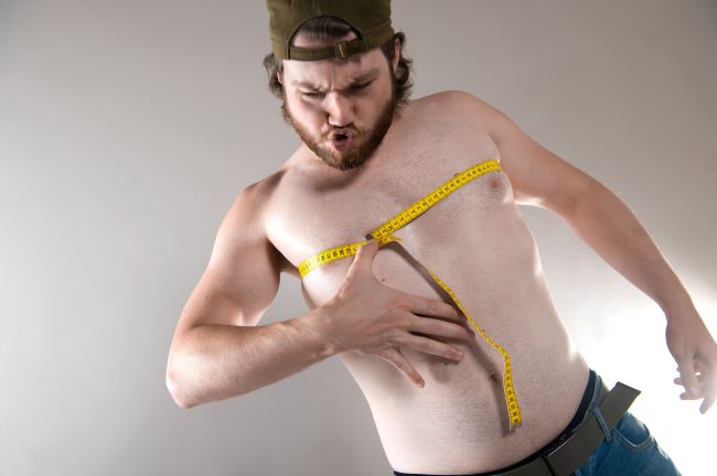 mężczyzna z nadwagą mierzący obwód klatki piersiowej