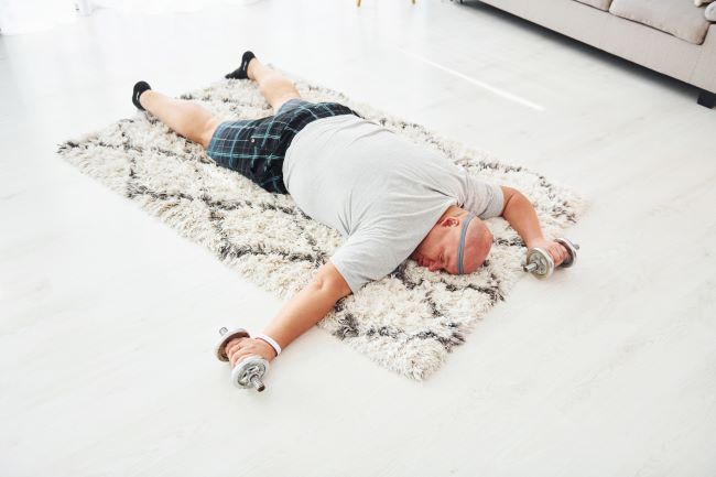 mężczyzna śpiący na podłodze po ćwiczeniach brzucha